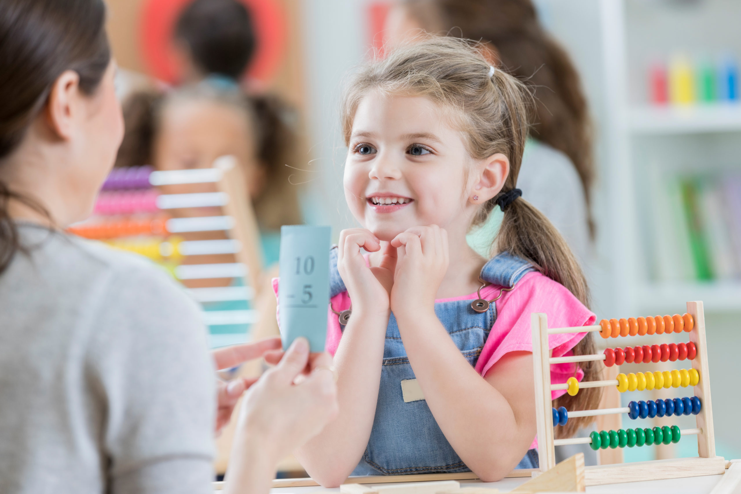 Attentive little girl enjoys math lesson with tutor